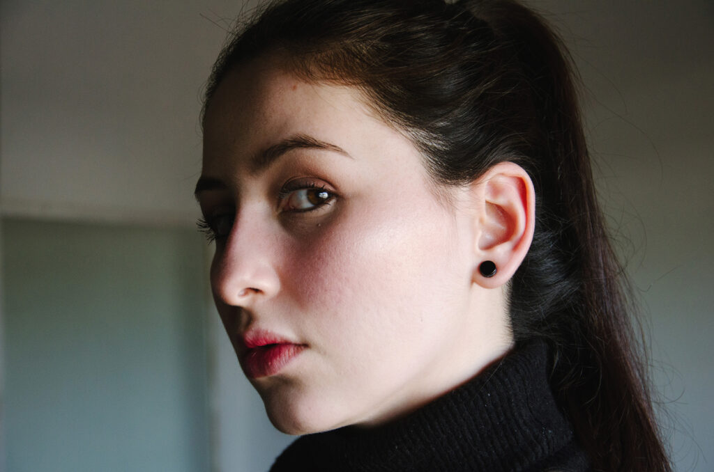 Gabriela Inzunza poses in a close-up shot showcasing her detailed facial features dark hair tied back and a black turtleneck sweater.